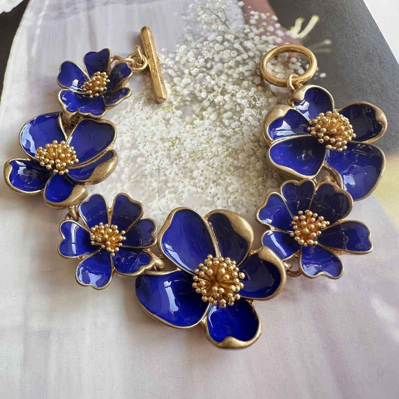 Deep blue enamel floral bracelet with gold-tone petal details and beaded flower center blooms