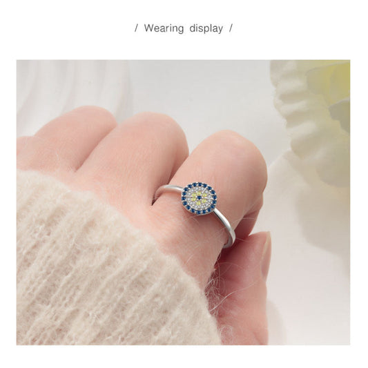 Sterling silver demon eye ring worn on hand, round blue CZ halo and yellow center