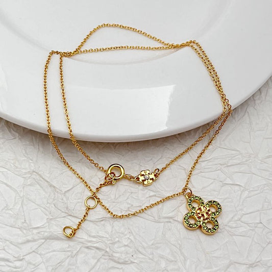 Gold tone clover necklace with two four-leaf pendants, rhinestones and ring clasp