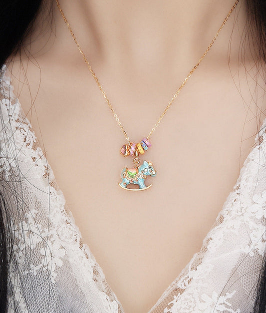 Enamel rocking horse necklace with blue horse charm and multicolor heart tag on gold chain