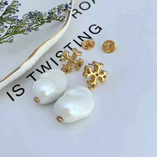 Pair of gold baroque cross earrings with white pearl drop dangles