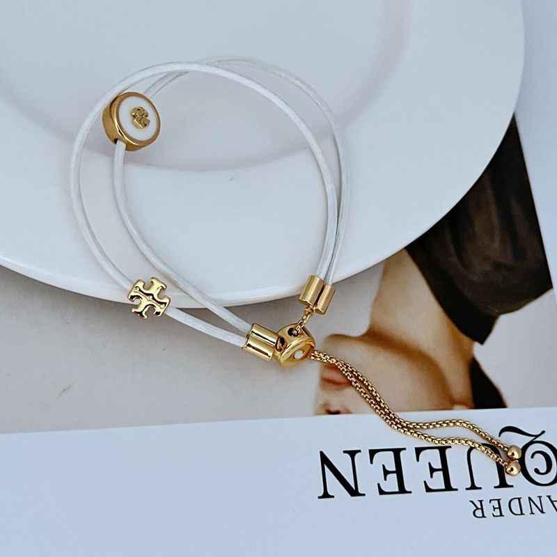 White leather bracelet with gold round charm, clasp hardware and short linked chain