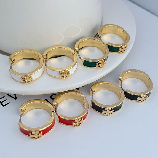 Assorted gold-tone round hoop earrings with enamel bands in green, red, and white