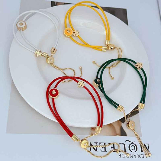 Layered leather bracelets: yellow, white and green with round logo charms and chains