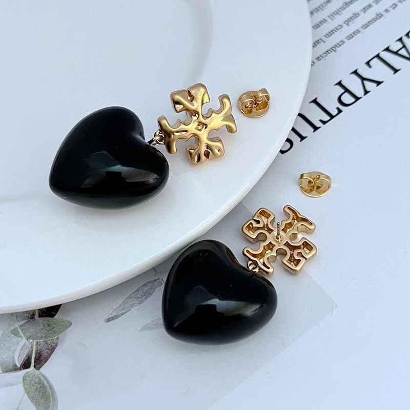 Black heart pendant earrings with gold snowflake studs, small back posts visible