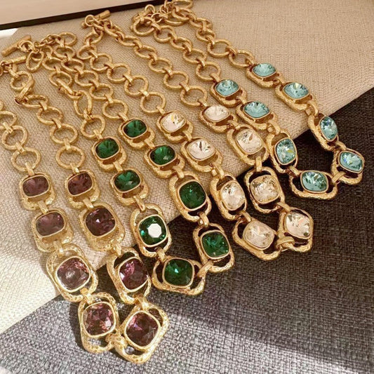 Gold-tone chain necklace with faceted crystals in green, white, and purple