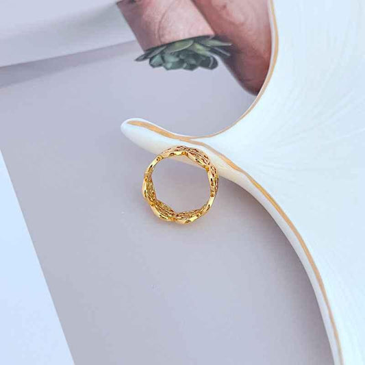 Gold-tone openwork ring with circular design and decorative lattice band
