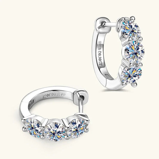 Silver huggie hoop earrings with three round moissanite stones and hinged clasp