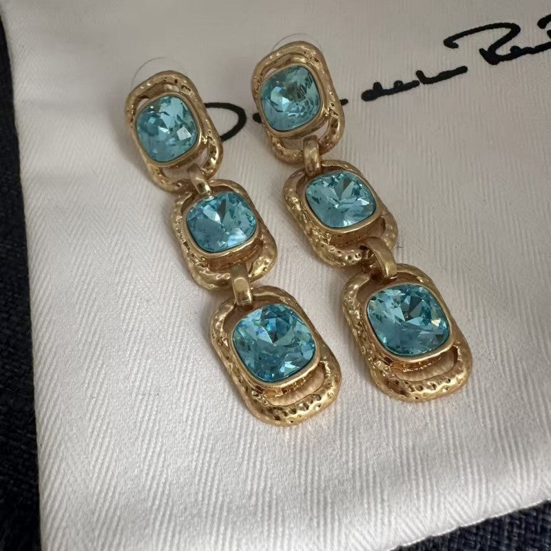 Clip-on drop earrings with gold-tone frames and light blue faceted crystals