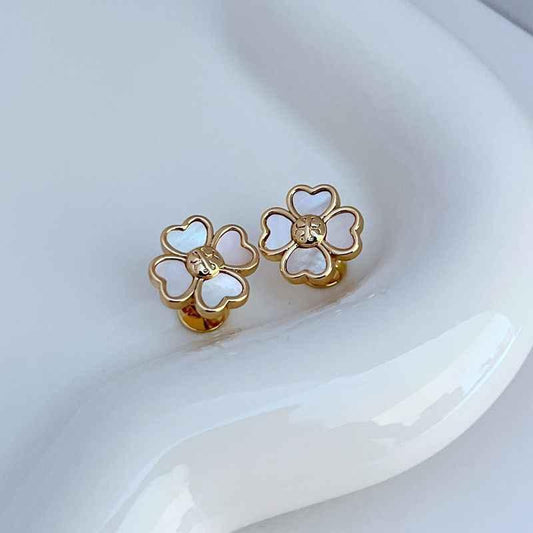 Gold four-leaf clover stud earrings with bee center and white enamel details