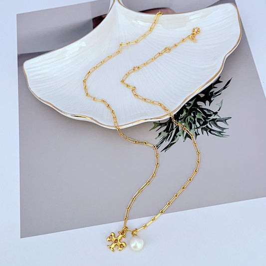 Gold-tone logo charm necklace with round white pearl pendant on linked chain
