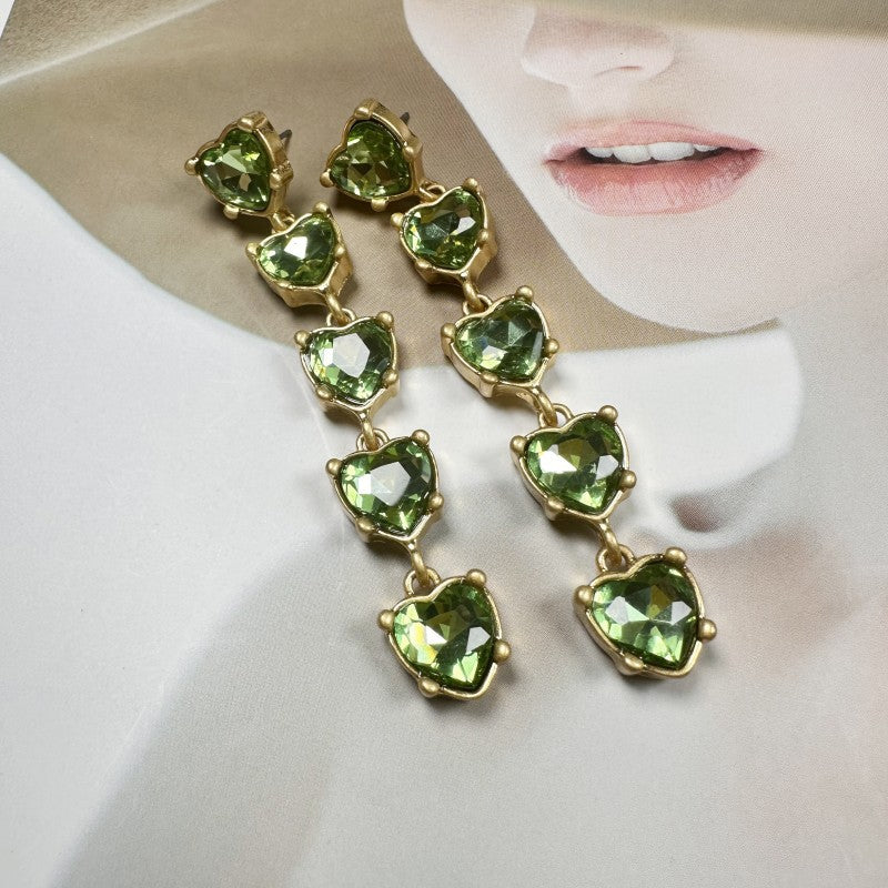 Heart-shaped crystal drop earrings with gold-tone links and green heart crystals.