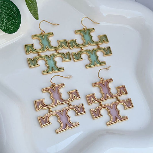 Acrylic logo drop earrings with gold-tone hooks and mint-green cutout letters