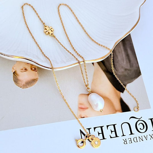 Gold-tone necklace with floral metal pendant and dangling white freshwater pearl