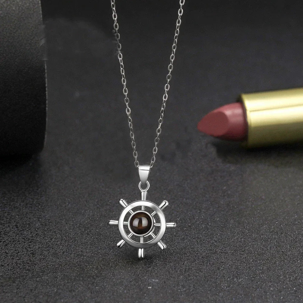 Ship wheel projection necklace on silver chain, detailed wheel with dark center