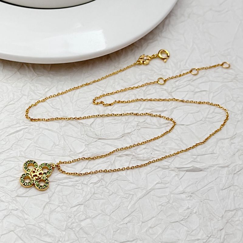 Gold tone four-leaf clover necklace with long chain and rhinestone pendant, green stones