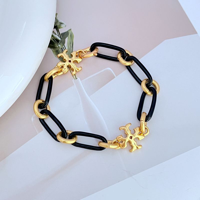 Black chunky chain bracelet with two gold logo charms and linked metal clasp