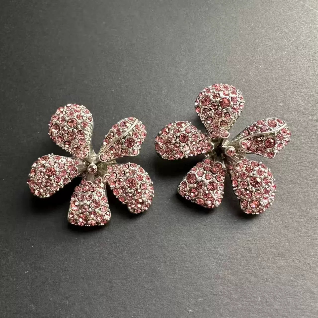 Pink rhinestone flower earrings with rounded petals, stud-style backing