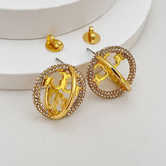 Gold-tone oval earrings with star orbit cutout and rhinestone pavé edge
