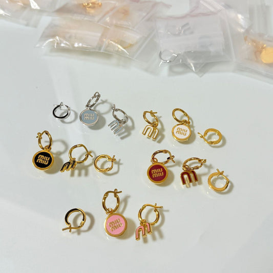 Three-piece asymmetric earring set on display: mixed silver and gold enamel hoops and charms