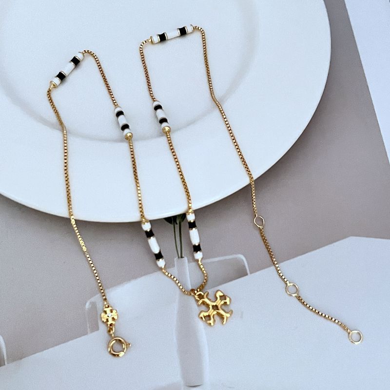 Gold-tone beaded pendant necklace with black and white bead segments