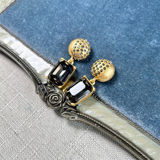 Gold-tone stud earrings with dark square-cut drop stones and round jeweled caps