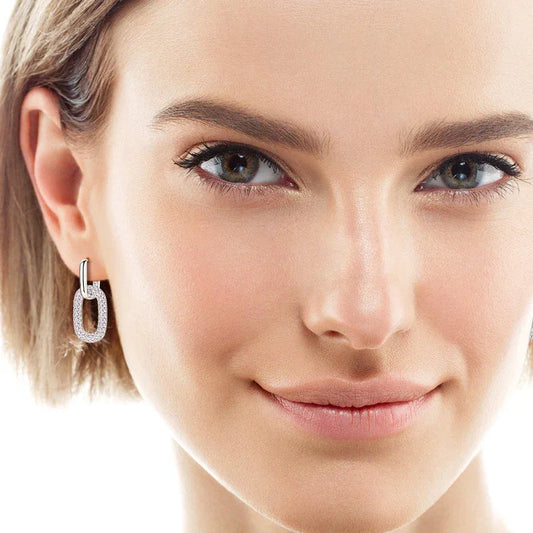 Silver-tone rectangular hoop earrings with clear moissanite pavé, worn on ear