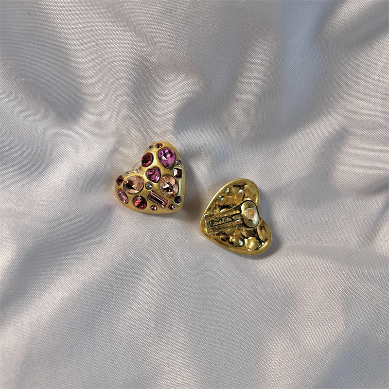 Heart-shaped crystal stud earrings, gold tone with pink and purple stones, front view