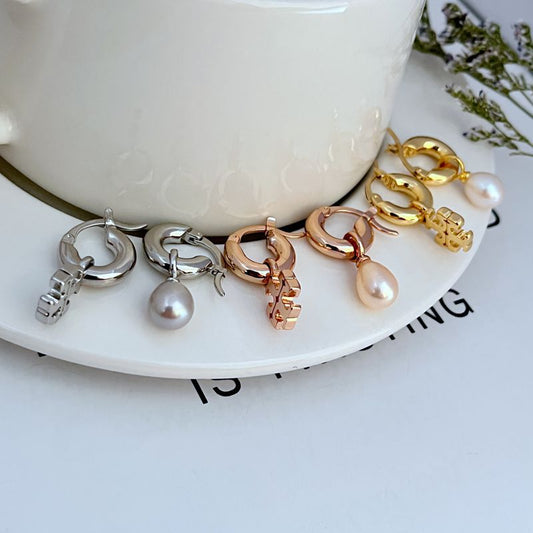 Mixed-metal asymmetrical pearl hoop earrings with dangling white pearl and charm detail
