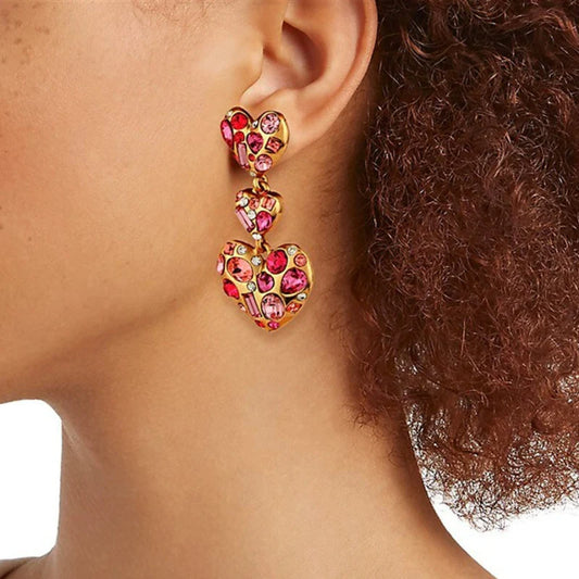 Heart drop earrings with pink crystal pavé and small dangling hearts on a wearer
