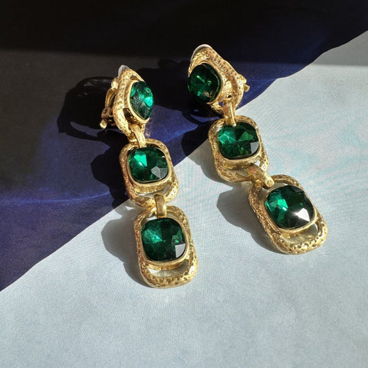 Clip-on drop earrings with gold-tone frames and green faceted crystals