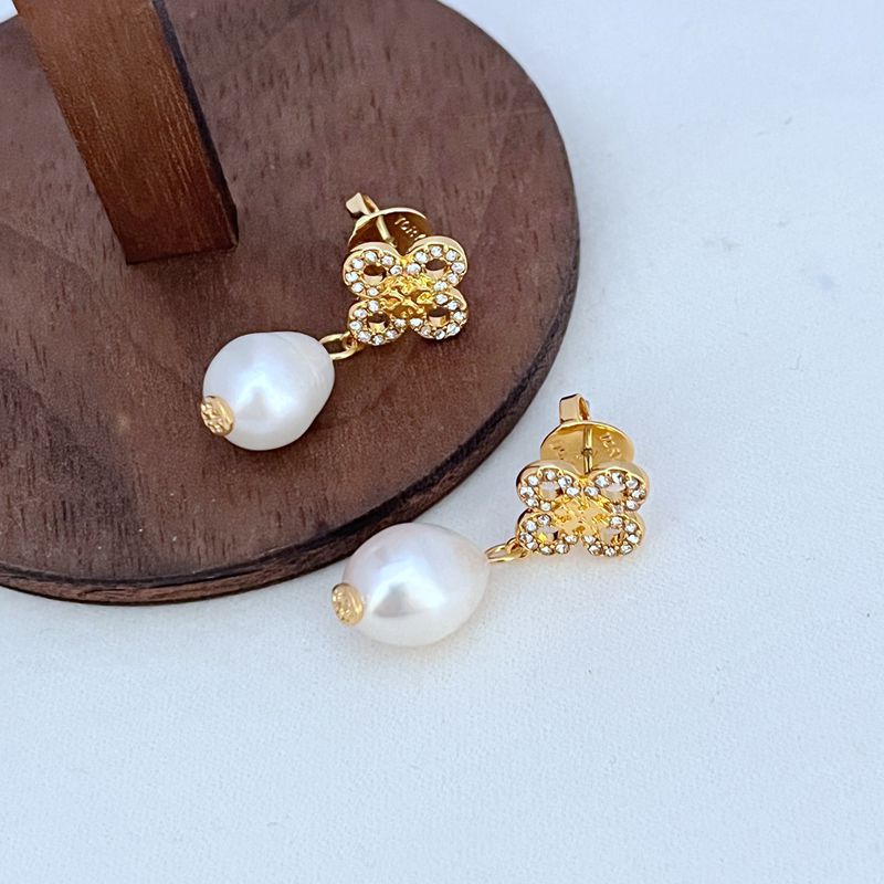 Gold four-leaf clover pearl drop earrings with rhinestone detail and white freshwater pearl