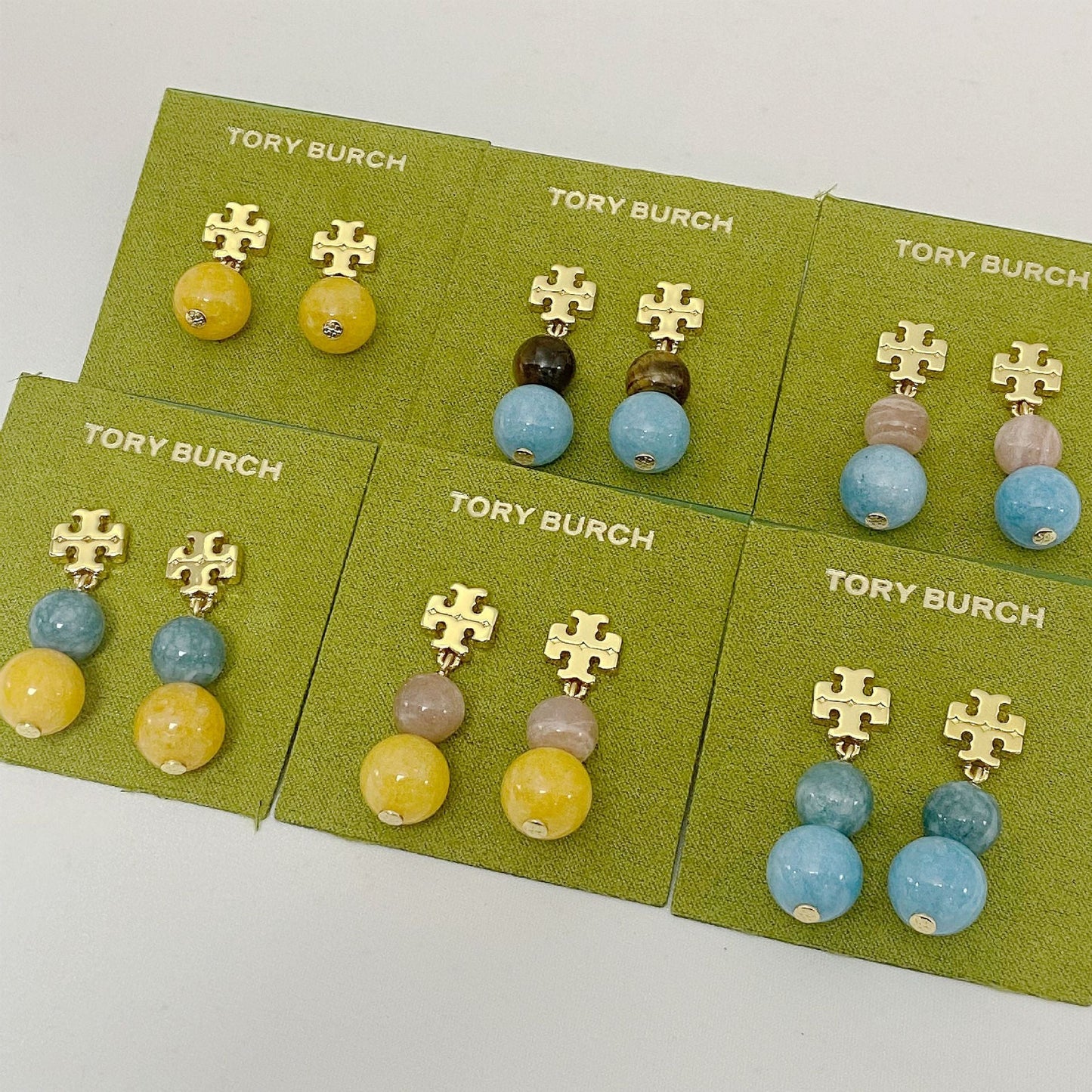 Tory Burch logo pendant earrings with mixed colored round agate beads on card