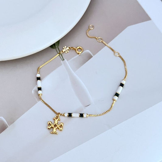 Gold-tone beaded pendant bracelet with black and white bead segments