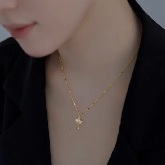Gold-tone ginkgo leaf pendant necklace with small dangling round crystal