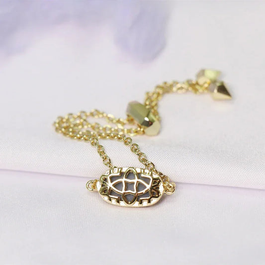 Gold pendant chain bracelet with compass wheel oval charm and dangling crystal caps