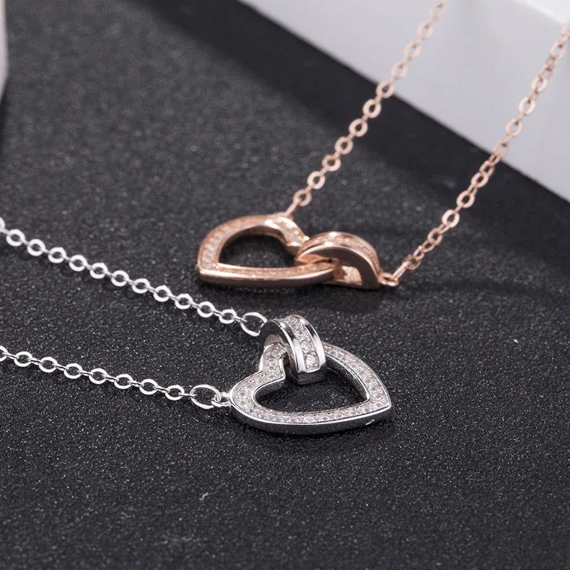 Two heart clasp pendant necklaces with rose-gold and silver hearts on chains