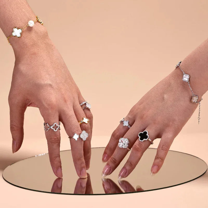 Four-leaf clover rings and charm bracelet in silver with white and dark stones