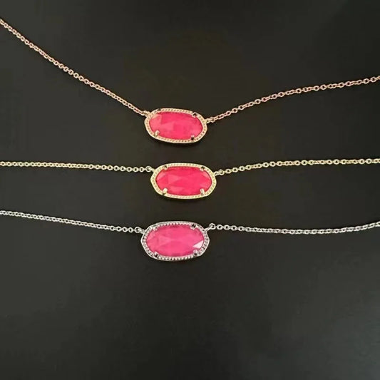 Teardrop pendant necklace with pink stone in gold-tone bezel and chain links
