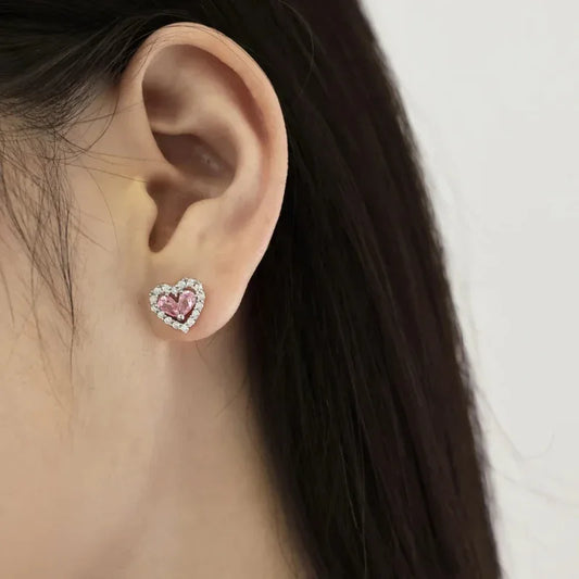 Heart-shaped stud earrings with pink cubic zirconia centers and silver-toned CZ halo