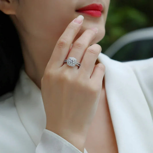 Moissanite ring on finger, silver band with round center stone and pavé detail