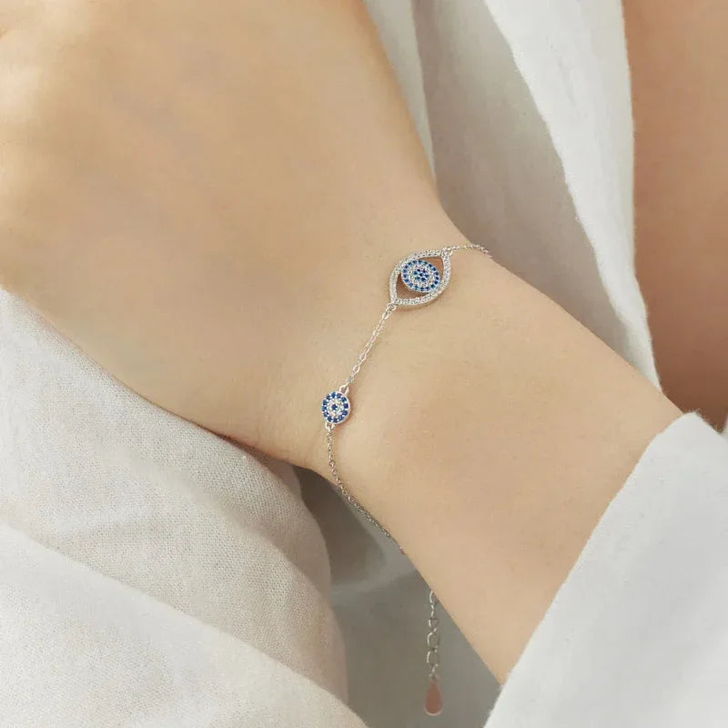 Silver evil eye charm bracelet with blue round eye charm and teardrop eye charm