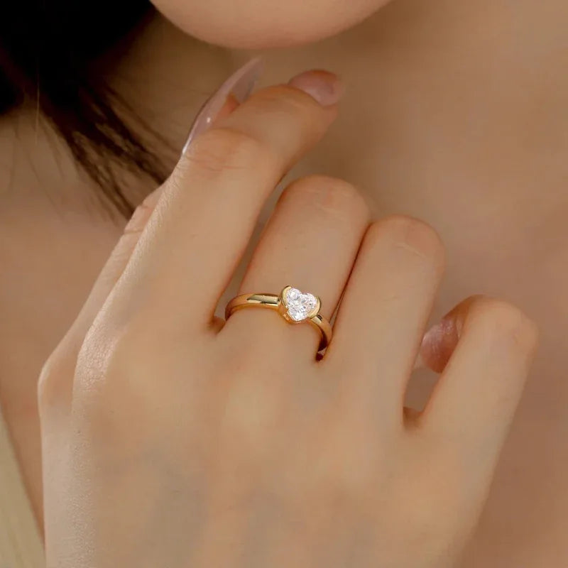 Gold-tone heart cz promise ring on finger, round center stone on slim band