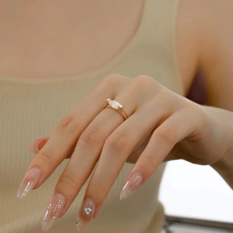 Gold tone oval marquise CZ solitaire ring on hand with slim band
