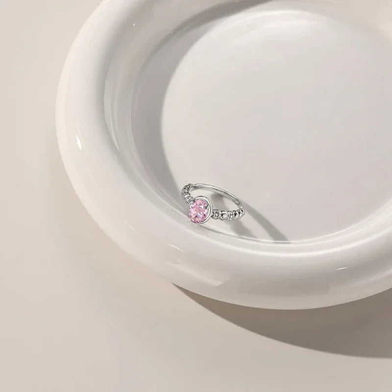 Sterling silver oval CZ eternity ring with pink oval center stone and pavé band detail