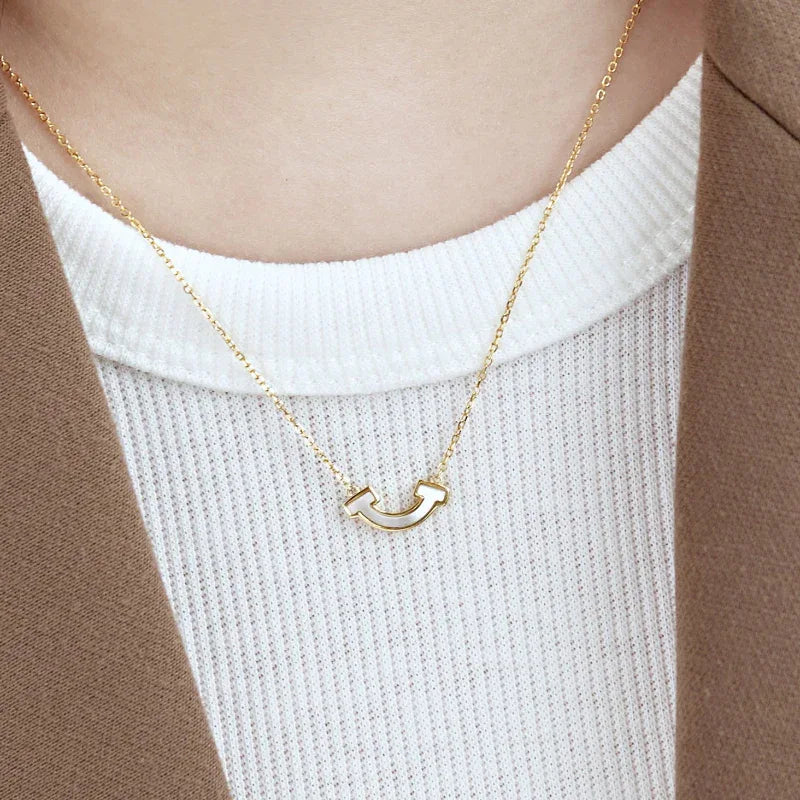 Gold-plated smile shell pendant necklace with bezel-set charm