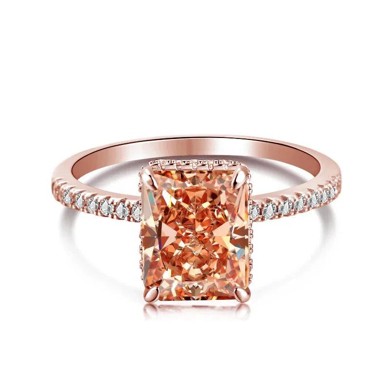 Rose-gold toned ring with radiant-cut orange center stone and crystal pavé band
