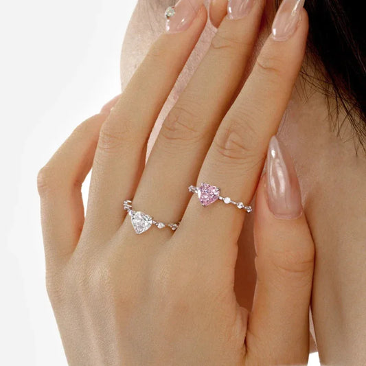 Sterling silver heart CZ rings on fingers: one with white heart stone, one with pink heart stone