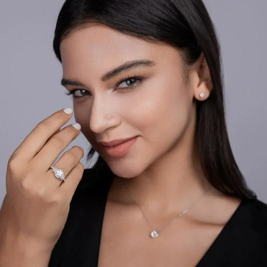 Moissanite engagement ring on finger with three-stone round sparkle settings in white gold