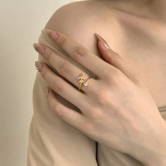 Gold airplane CZ ring on a hand, featuring small stones along the airplane detail